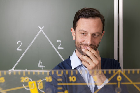 Smiling teacher in classroom teaching geometry stock photo