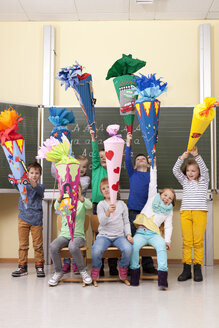 Gruppe glücklicher Schüler mit Schultüten im Klassenzimmer - MFRF000155