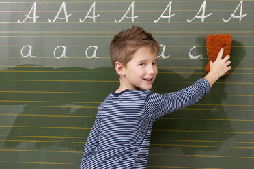 Schuljunge an der Tafel, der den Buchstaben A wegwischt - MFRF000093