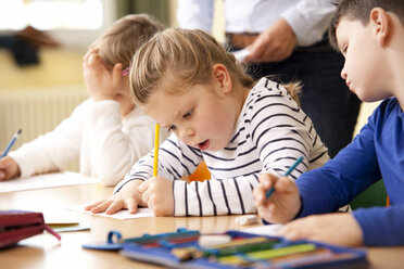 Schüler arbeiten an Arbeitsblättern im Klassenzimmer - MFRF000123