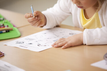 Schülerin arbeitet an einem Arbeitsblatt im Klassenzimmer - MFRF000101