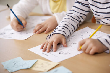 Schoolgirls working on work sheets in classroom - MFRF000103