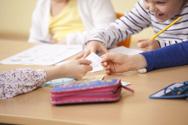 Schüler, die einen Zettel im Klassenzimmer abgeben - MFRF000152