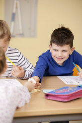 Pupils handing over slip of paper in classroom - MFRF000105