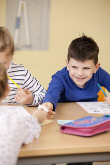 Schüler, die einen Zettel im Klassenzimmer abgeben - MFRF000105