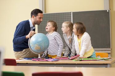 Lehrer und Schüler mit Globus im Klassenzimmer - MFRF000131