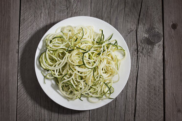 Zucchini spirals on plate and wood - CSF024741