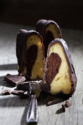 Stück Marmorkuchen, Schokolade und Messer auf Holz - CSF024756
