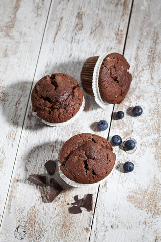 Schokoladenmuffins und Blaubeeren auf Holz, lizenzfreies Stockfoto