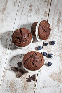 Schokoladenmuffins und Blaubeeren auf Holz - CSF024761