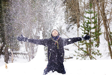 Mann spielt mit dem Schnee im Wald - GEMF000089