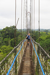 Ecuador, Amazonasgebiet, Tourist auf Hängebrücke über Regenwald - FOF007766