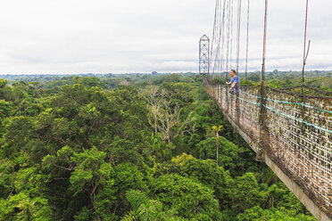 Ecuador, Amazonasgebiet, Tourist auf Hängebrücke über Regenwald - FOF007769