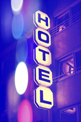 Germany, Duesseldorf, facade of hotel with lighted sign at night - HOHF001299