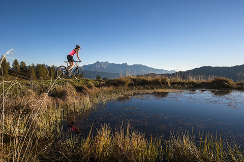 Österreich, Altenmarkt-Zauchensee, junge Frau fährt Mountainbike, lizenzfreies Stockfoto