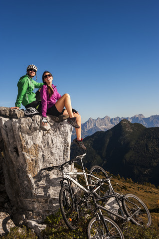 Austria, Altenmarkt-Zauchensee, young couple with mountain bikes in the mountains stock photo