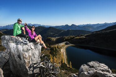 Austria, Altenmarkt-Zauchensee, young couple with mountain bikes in the mountains - HHF005197