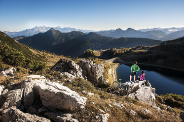 Österreich, Altenmarkt-Zauchensee, junges Paar mit Mountainbikes in den Bergen - HHF005207