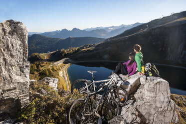 Österreich, Altenmarkt-Zauchensee, junges Paar mit Mountainbikes in den Bergen - HHF005208