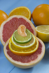 Stack of orange, lime, lemon and tangerine slices on half of grapefruit - YFF000336