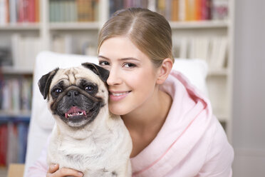 Portrait of young woman with pug - DRF001598