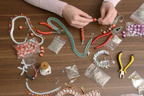 Junge Frau arbeitet an selbstgemachtem Schmuck, lizenzfreies Stockfoto