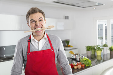 Portrait of man with cooking spoon between his teeth - PDF000842