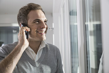 Portrait of smiling man telephoning with smartphone - PDF000866