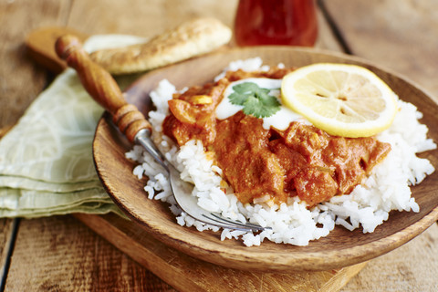 Seitan Tikka Masala auf Reis mit Sojajoghurt, serviert mit Paratha-Brot, lizenzfreies Stockfoto