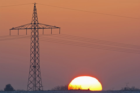 Deutschland, Sonnenuntergang neben Strommast, lizenzfreies Stockfoto