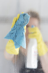 Woman cleaning glass pane - CHPF000096