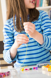 Girl stringing pearls - LVF003004