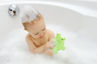 Babymädchen mit Thermometer in einer Badewanne - LHF000438