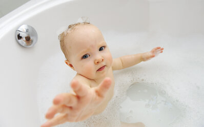 Babymädchen in einer Badewanne mit ausgestrecktem Arm - LHF000441