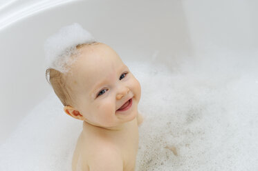Lächelndes kleines Mädchen in einer Badewanne - LHF000442