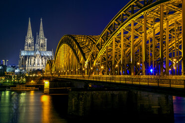 Deutschland, Köln, beleuchteter Kölner Dom und Hohenzollernbrücke bei Nacht - YRF000075