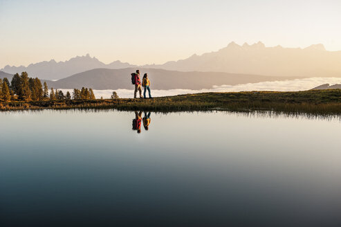 Austria, Altenmarkt-Zauchensee, young couple at mountain lake in the Lower Tauern - HHF005142