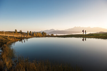 Austria, Altenmarkt-Zauchensee, hikers at mountain lake in the Lower Tauern - HHF005143