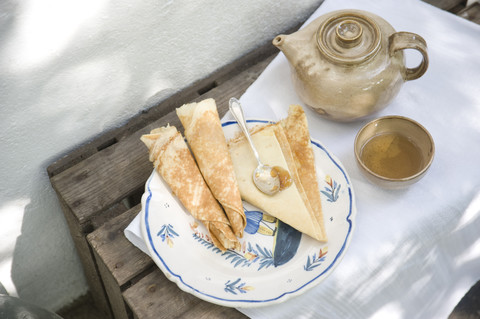 Teller mit Crêpes, Tasse Tee und Teekanne, lizenzfreies Stockfoto