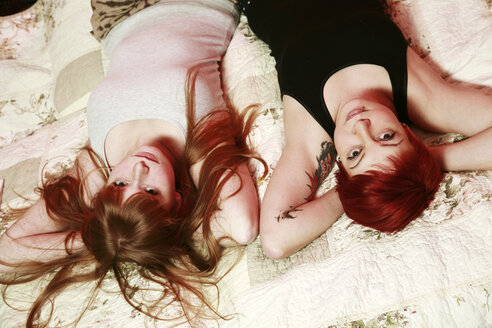 Portrait of two female friends relaxing on a blanket at home - VEF000043