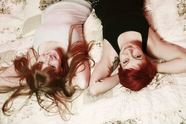 Portrait of two female friends relaxing on a blanket at home - VEF000044