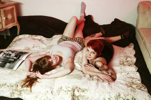 Two female friends relaxing on a blanket at home - VEF000046