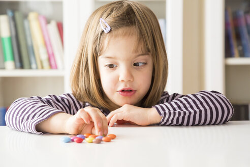 Kleines Mädchen spielt mit Schokoladenknöpfen - LVF003033