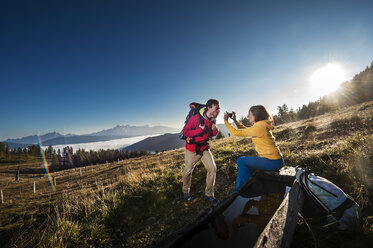 Österreich, Altenmarkt-Zauchensee, junges Paar beim Fotografieren auf einer Wanderung in den Niederen Tauern - HHF005133