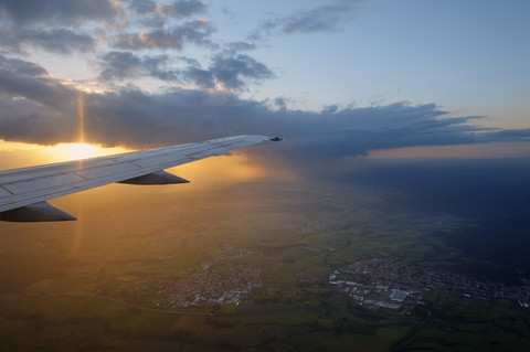 Germany, wing of an airplane with clouds at sunset stock photo