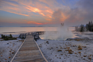 USA, Wyoming, Yellowstone-Nationalpark, Sonnenaufgang am West Thumb Geysirbecken mit Holzsteg - RUEF001533