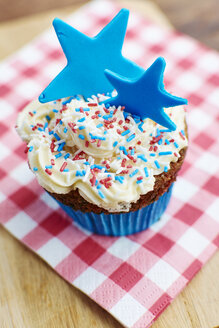 Cupcakes with a white frosting, colorful sprinkles and a blue star made from fondant - HAWF000718