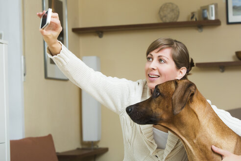 Woman taking selfie with her Rhodesian Ridgeback dog - JTLF000052
