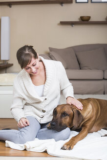 Woman caressing her Rhodesian Ridgeback dog - JTLF000055