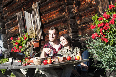 Österreich, Altenmarkt-Zauchensee, Pärchen macht Pause auf Almhütte - HHF005145